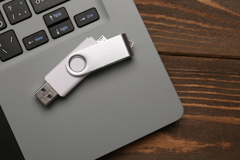 Usb,Flash,Drive,And,Laptop,On,Wooden,Background,,Closeup
